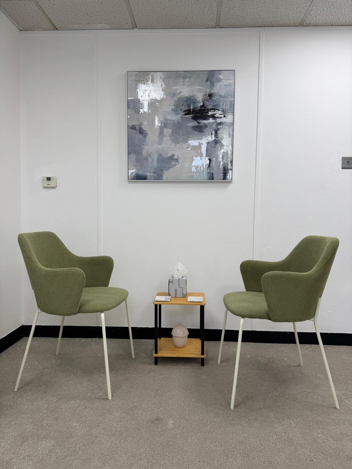 Therapy room at Dolphin House Arts with two green armchairs and a small table